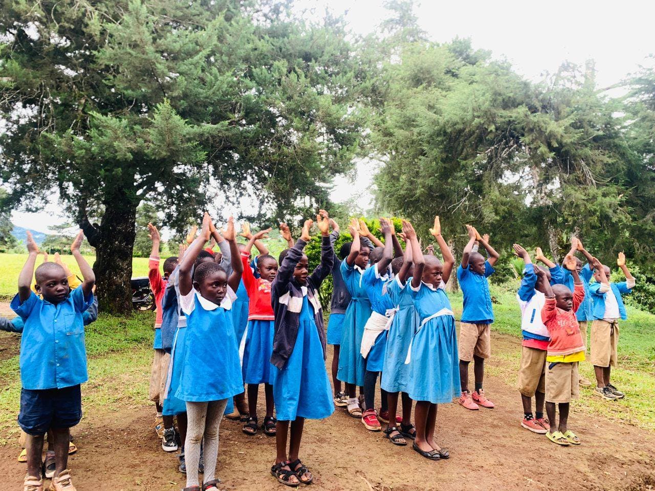 Schoolchildren cheering with their arms raised in joy